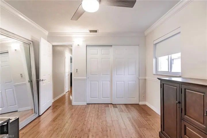 Unfurnished bedroom featuring ceiling fan, ornamental molding, and light hardwood / wood-style floors