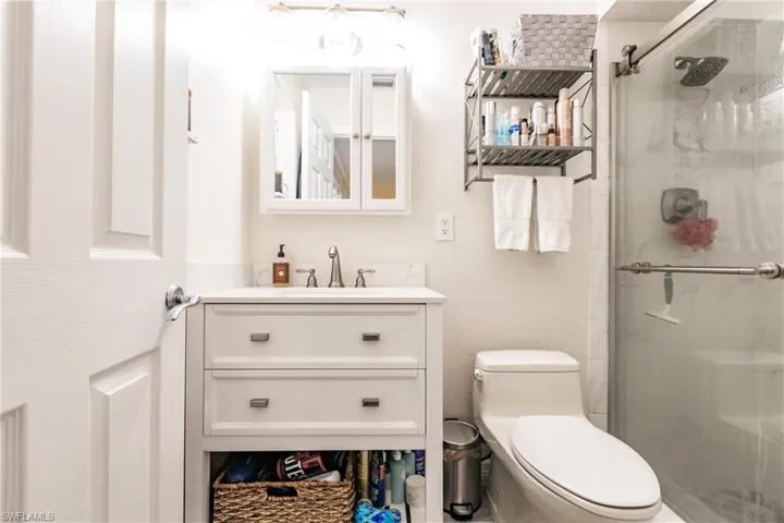 Bathroom with vanity, toilet, and a shower with door