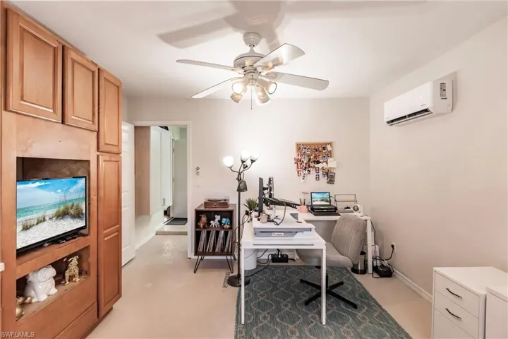 Office featuring a wall mounted air conditioner and ceiling fan