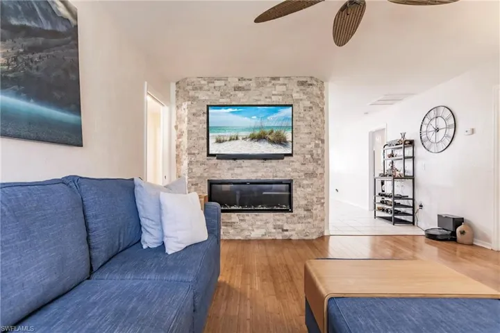 Living room featuring a fireplace, ceiling fan, and hardwood / wood-style floors