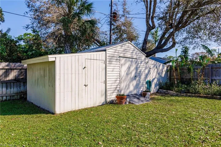View of outdoor structure featuring a lawn