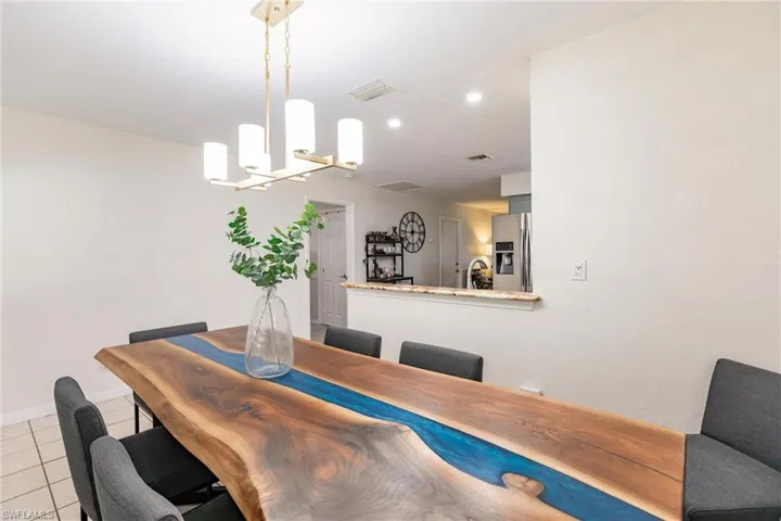 Tiled dining room featuring a notable chandelier and sink