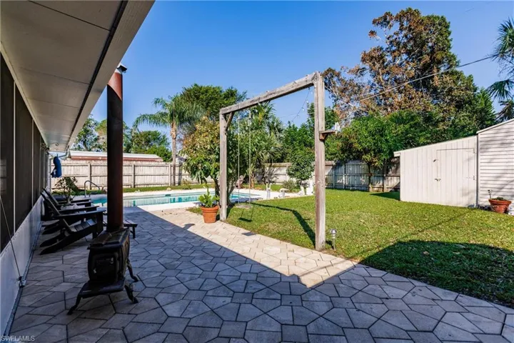 View of patio / terrace with a fenced in pool and a storage shed