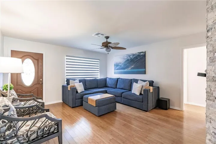 Living room with ceiling fan and light hardwood / wood-style flooring