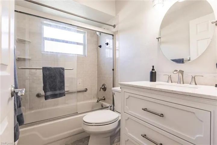 Full bathroom featuring vanity, toilet, and enclosed tub / shower combo