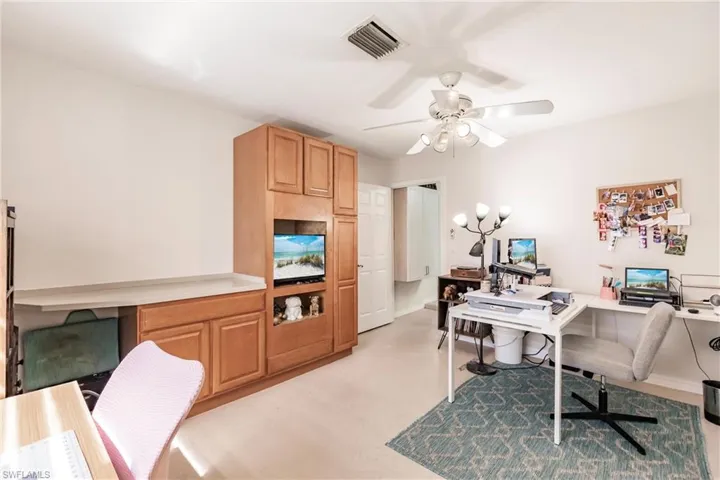 Office space with built in desk and ceiling fan