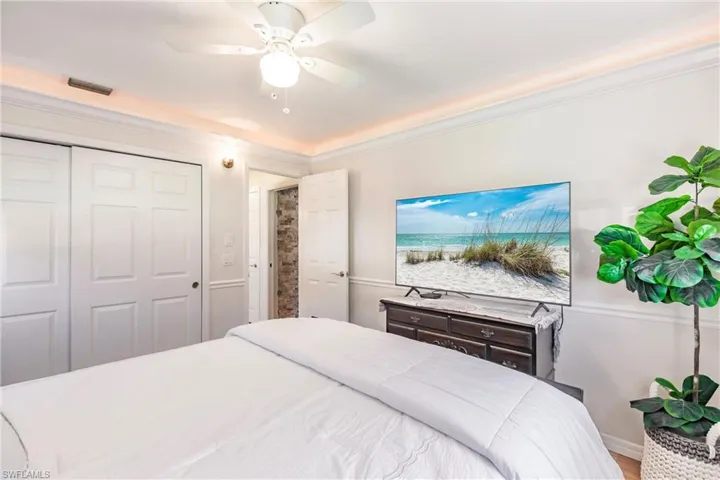 Bedroom with ornamental molding, ceiling fan, hardwood / wood-style floors, and a closet