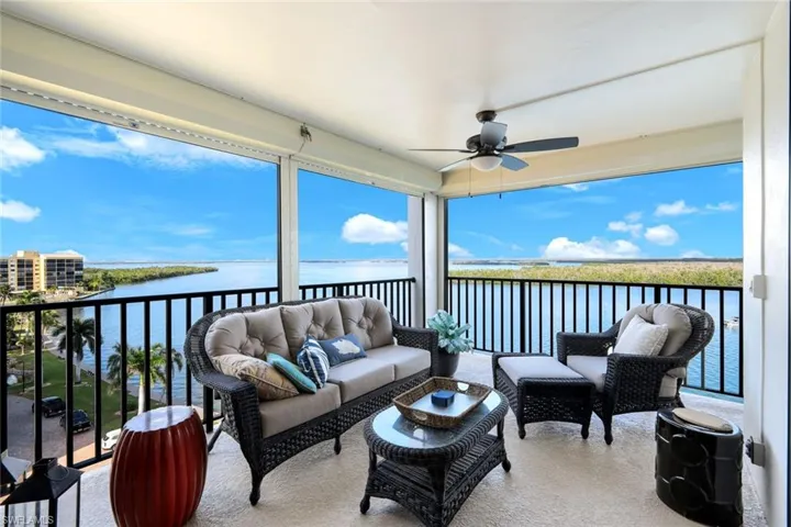 Lanai featuring a ceiling fan, a water view, an outdoor living space, and plenty of natural light