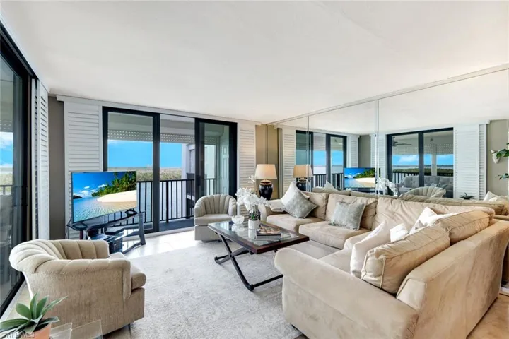 Tiled living area with floor to ceiling windows and healthy amount of natural light
