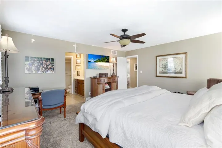 Bedroom with ceiling fan and light colored carpet