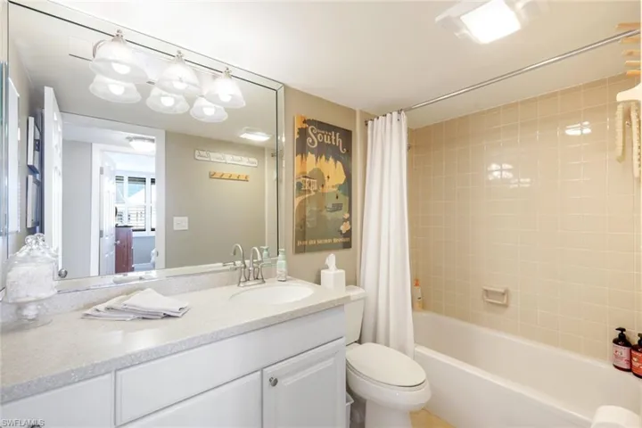 Full bath with shower / tub combo with curtain and vanity