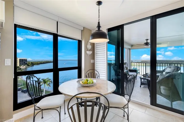 Dining room with a water view, light tile floors, and ceiling fan