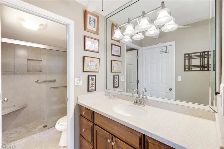Full bath with vanity, a tile shower, and light tile patterned floors