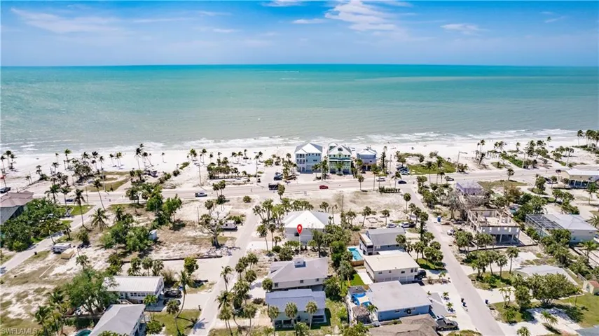 Aerial view featuring a water view and a beach view