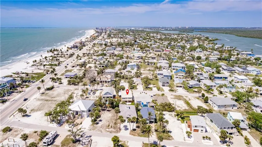 Birds eye view of property featuring a beach view and a water view