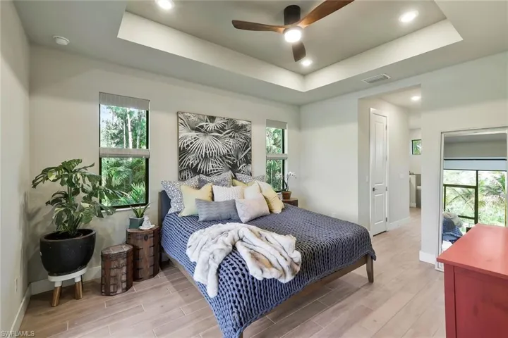 Spacious primary suite with tray ceiling, garden and lake views, dual walk-in closets