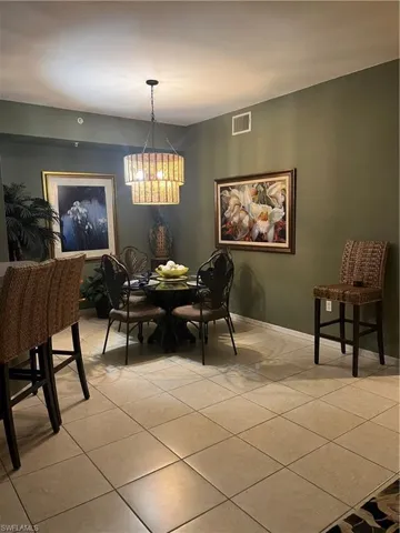 Dining area featuring a tiered chandelier and contrasting wall color