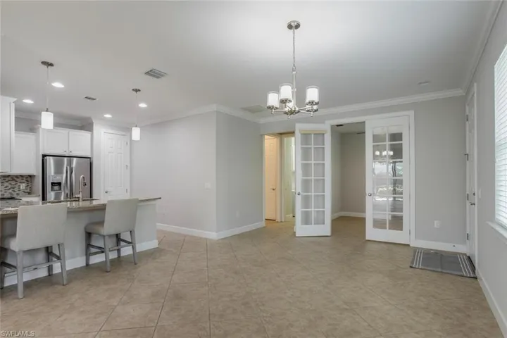Great room view including kitchen and French glass doors opening to the bonus room, perfect for home office, den, craft room.