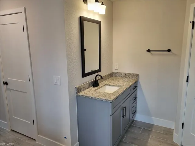 Bathroom featuring vanity, wood tiled floors, and a textured wall