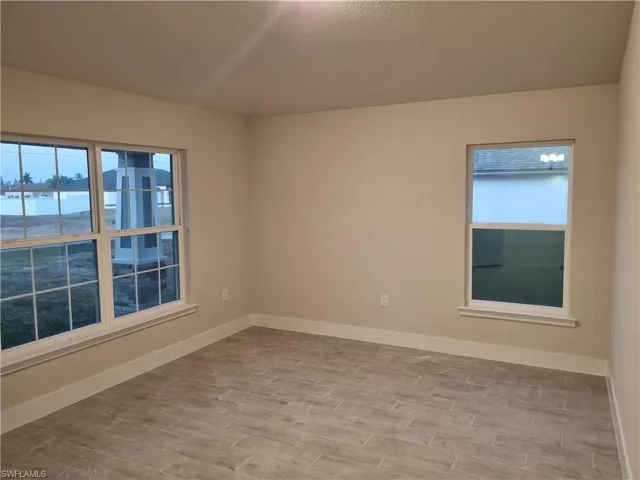 Spare room with baseboards and wood finish floors
