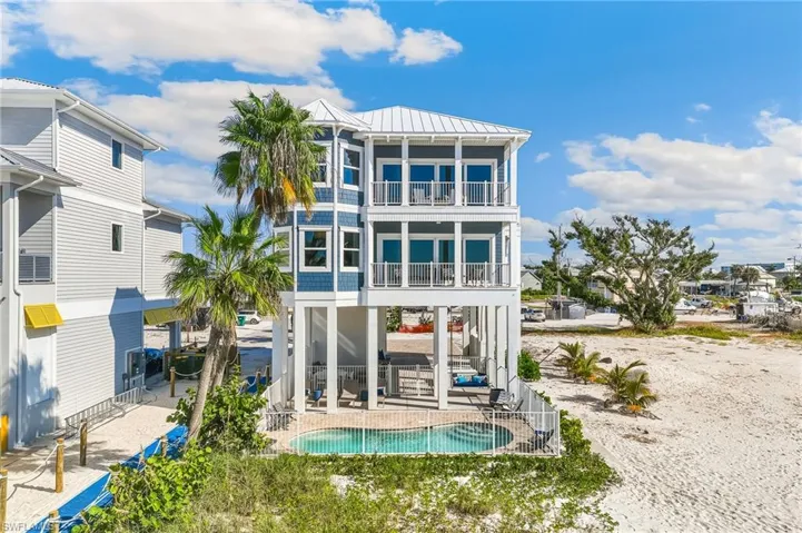 Back of property featuring a standing seam roof, a metal roof, a patio area, and a balcony