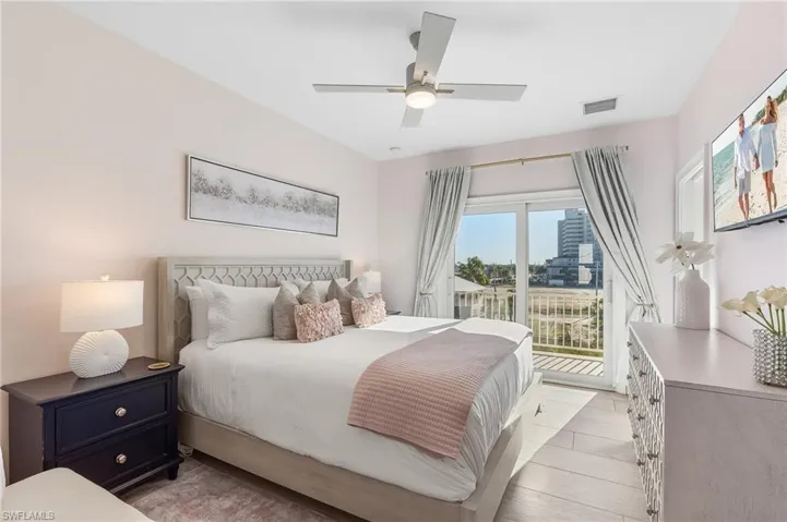 Bedroom with access to exterior, light wood finished floors, and a ceiling fan