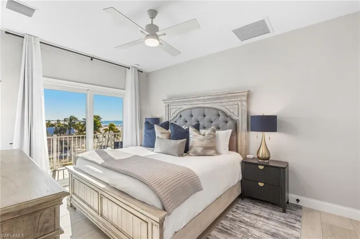 Bedroom featuring light wood finished floors, ceiling fan, access to exterior, and a water view