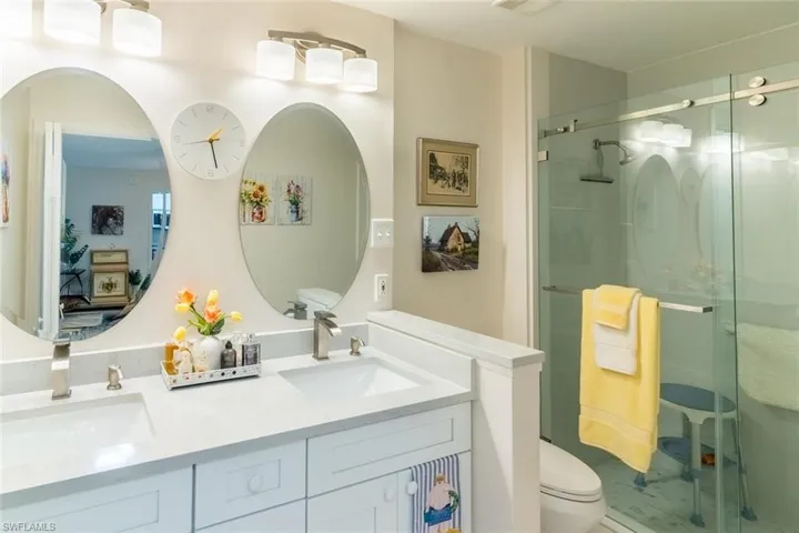 Bathroom featuring a shower stall and double vanity