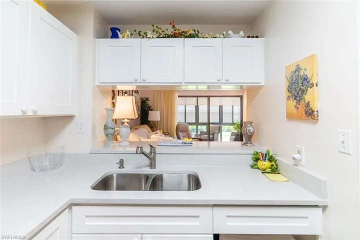Kitchen with light stone counters and white cabinets