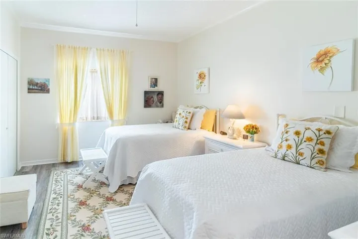 Bedroom with vinyl wood-like flooring and crown molding