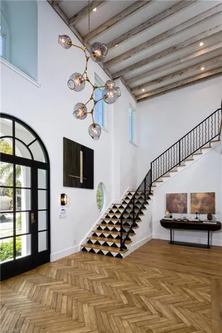 Entryway featuring parquet floors, a high ceiling, and a chandelier