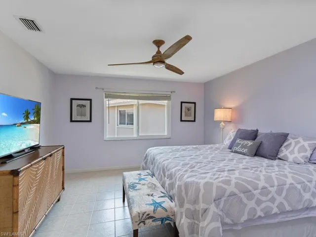 Bedroom with ceiling fan and light tile patterned flooring