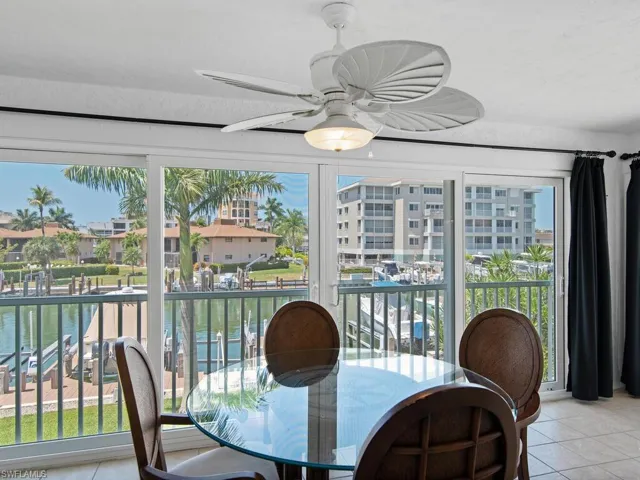 Tiled dining space featuring a water view, ceiling fan, and plenty of natural light