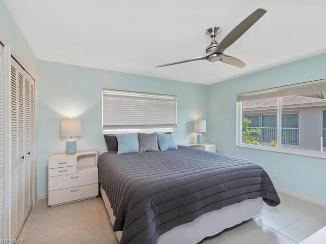 Tiled bedroom featuring ceiling fan and a closet