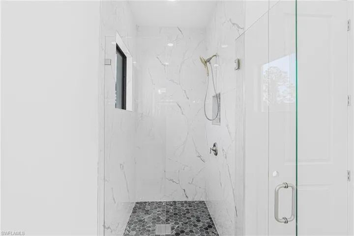 Full bathroom with a marble finish shower