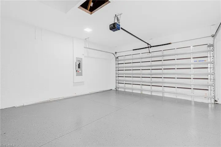 Garage featuring electric panel and a garage door opener