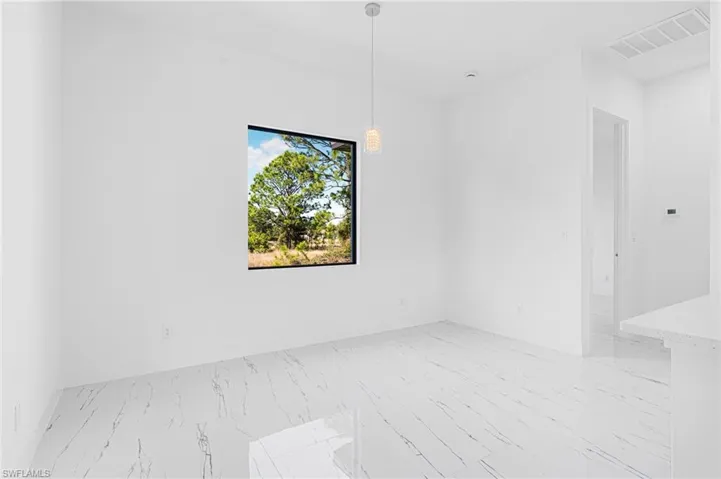 Empty room featuring light marble finish floors and baseboards