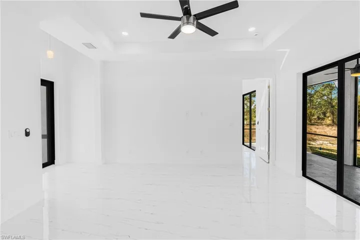 Empty room featuring ceiling fan, light marble finish floors, and recessed lighting