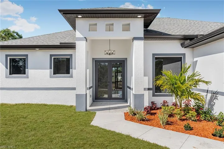 Doorway to property with a shingled roof, french doors, and stucco siding