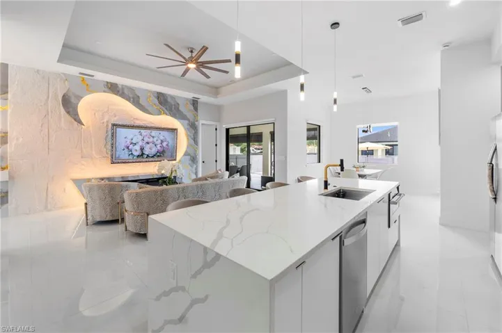 Spacious open-concept living area featuring an oversized kitchen island with an undermount sink and a gold-tone faucet