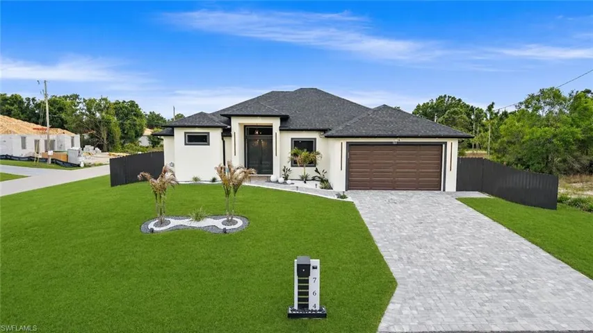 Contemporary single-story residence with a dark shingle roof and light-colored stucco exterior