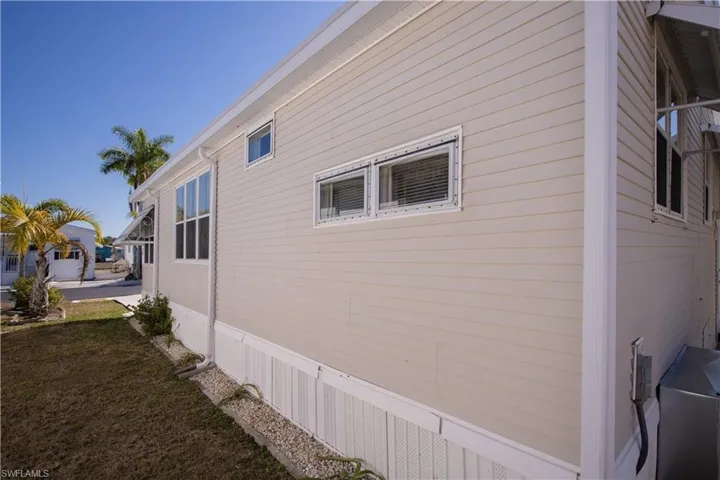 Exterior featuring light-colored horizontal siding, dual-pane windows, and white trim accents