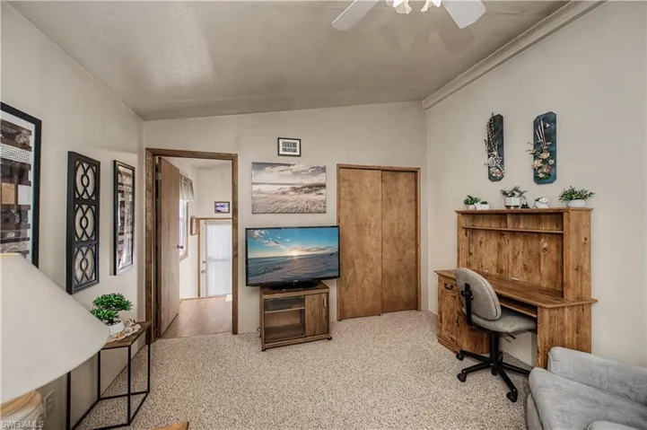 Vaulted ceiling, ceiling fan, carpeted flooring, and dual sliding wood-finish closet doors