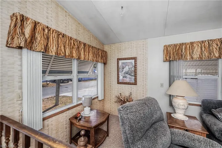 Vaulted ceilings featuring multi-pane windows with horizontal metal blinds and wall-mounted valances