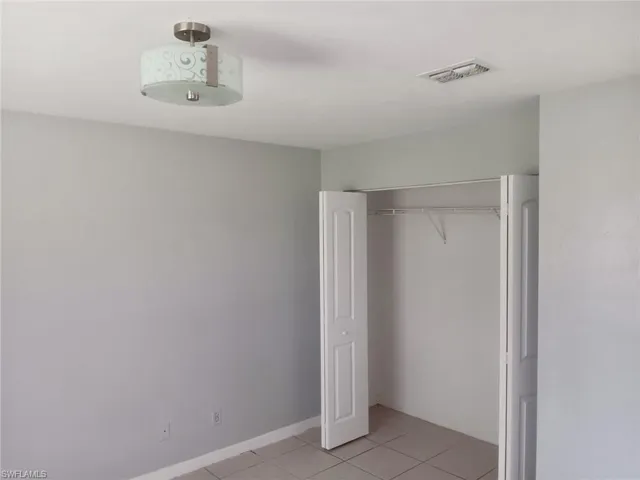 Unfurnished bedroom featuring light tile patterned floors and a closet
