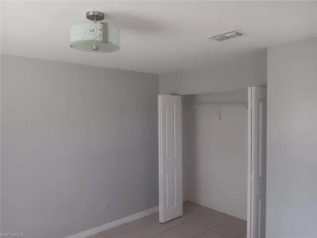 Unfurnished bedroom with light tile patterned floors and a closet