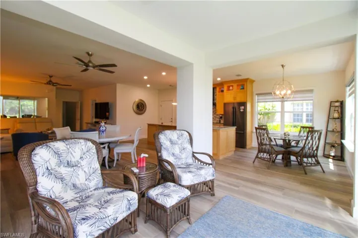 Living room with light hardwood / wood-style floors and ceiling fan with notable chandelier