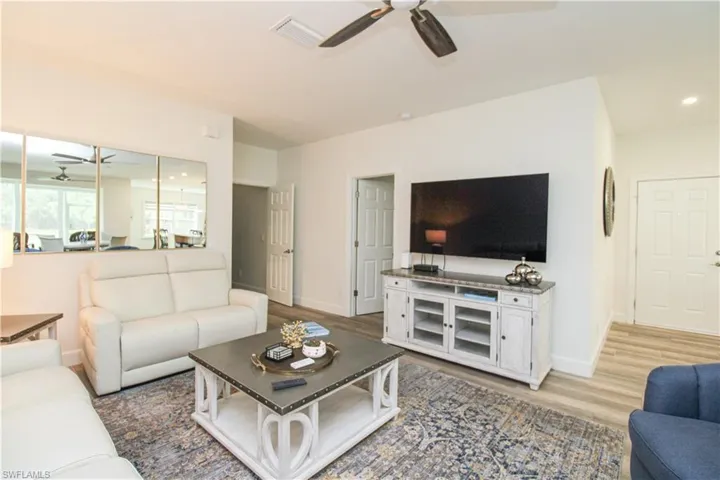 Living room with ceiling fan and hardwood / wood-style floors