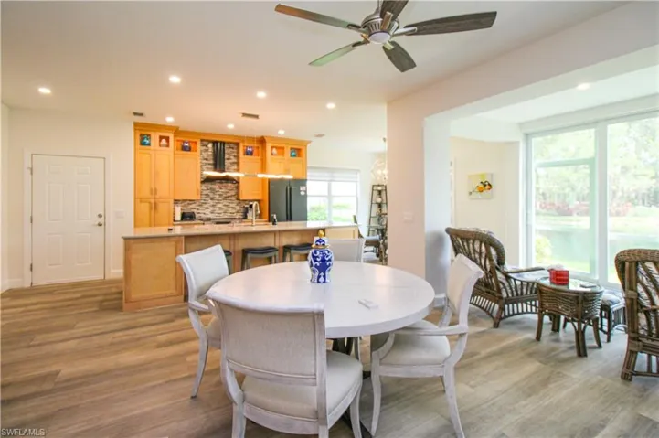 Dining room featuring sink, ceiling fan, light hardwood / wood-style floors, and a healthy amount of sunlight