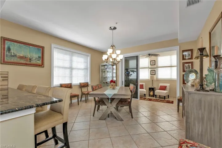 Tiled dining area with a healthy amount of sunlight and a notable chandelier